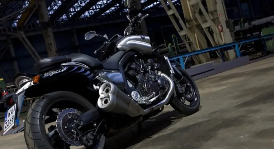 Potężny motocykl Yamaha V-Max 1700 z chromowanymi elementami, stojący w industrialnym wnętrzu.