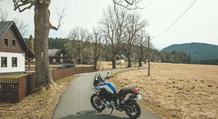 Motocykl czeka na przygodę na malowniczej drodze. Idealne miejsce na odkrywanie tras motocyklowych w Czechach.