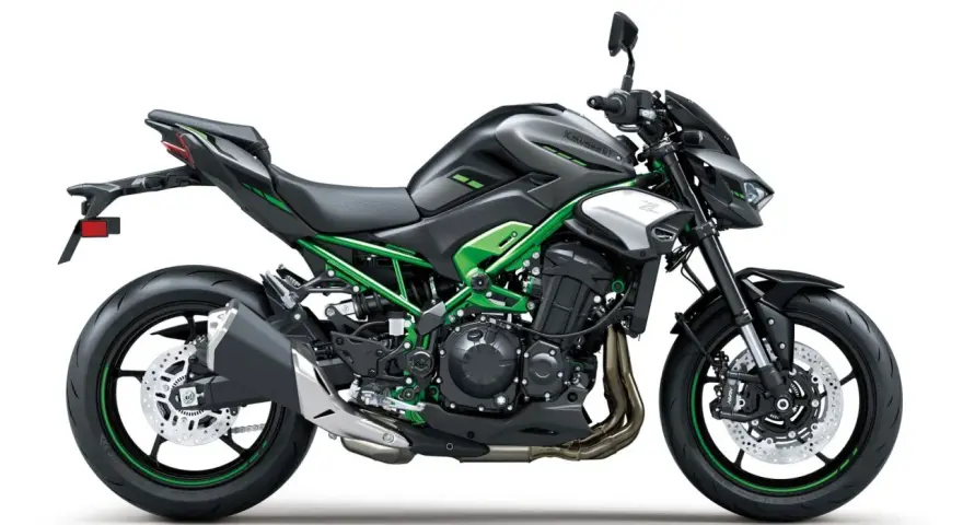 Czarny motocykl Kawasaki Z900 z zielonym stelażem i akcentami. Potężna maszyna gotowa na przygodę.