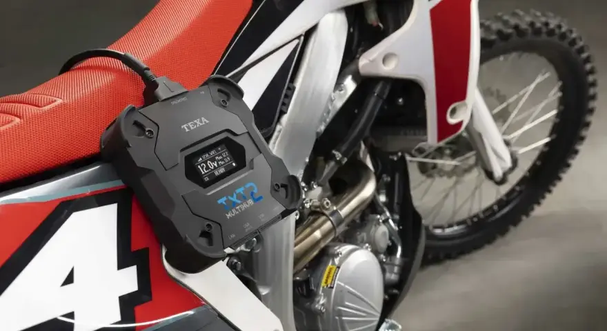 Urządzenie diagnostyczne TEXA TXT2 podłączone do motocykla, sprawdzające, czy jest **brak iskry**.