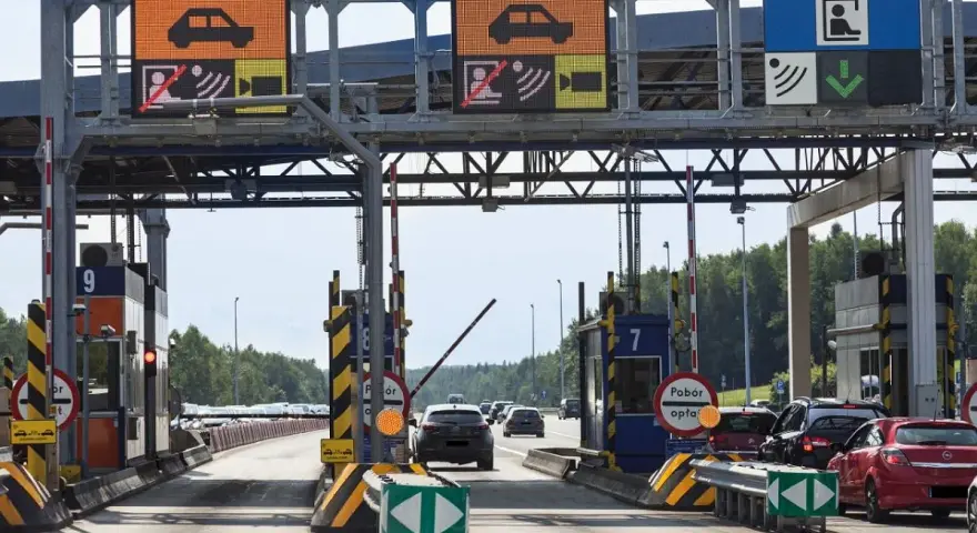 Pobieranie opłat na autostradzie A4. Samochody zbliżają się do bramek, na których wyświetlane są informacje o opłatach.