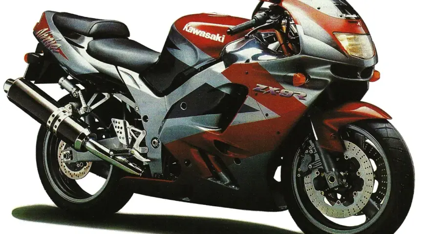 Sportowy motocykl Kawasaki ZX9R w czerwono-srebrnej kolorystyce, gotowy do jazdy.