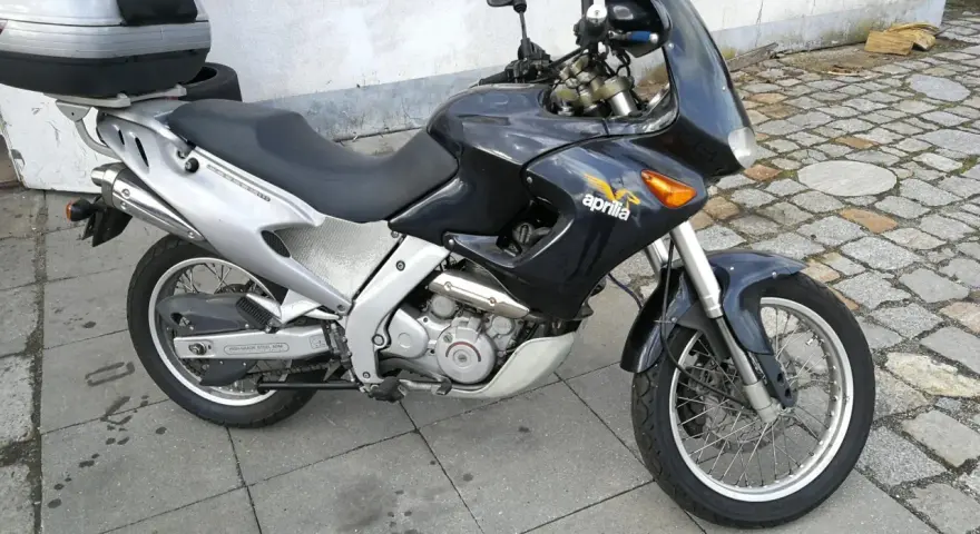 Czarny motocykl Aprilia Pegaso 650 z kufrem na bagaż, gotowy na przygodę.