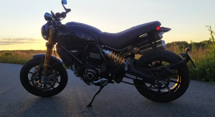 Czarny Ducati Scrambler 1100 na tle zachodzącego słońca. Idealny na wieczorną przejażdżkę.