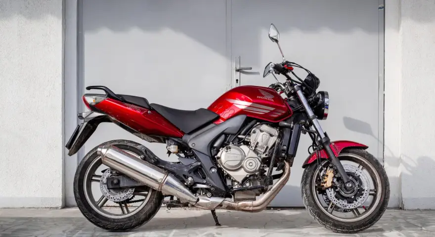Czerwony motorower Honda Hornet, idealny do miasta. Zastanawiasz się, ile kosztuje motorower tej klasy?