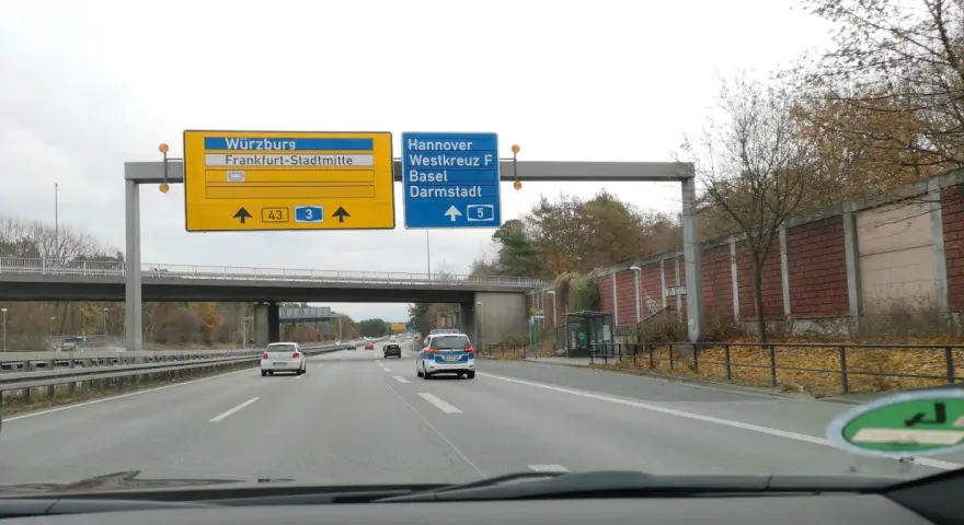 Autostrada A5. Znaki kierują do Würzburga, Frankfurtu, Hanoweru i Darmstadt. Na drodze ruch samochodowy.