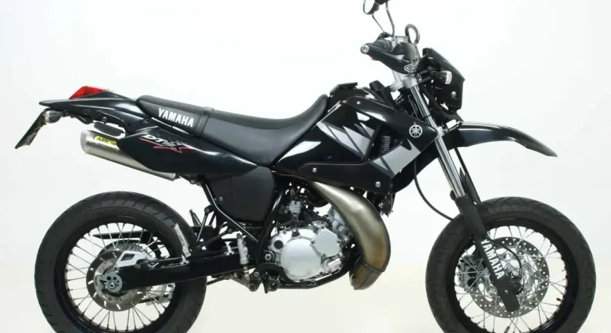 Czarny motocykl Yamaha DT 125 z naklejkami DTX i wydechem Arrow. Idealny do miasta i terenu, sprawdź yamaha dt 125 dane techniczne.