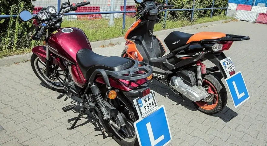 Dwa pojazdy, motorower i skuter, gotowe do nauki jazdy. Na każdym z nich widnieje tablica z literą "L", symbolizująca kartę motorowerową.
