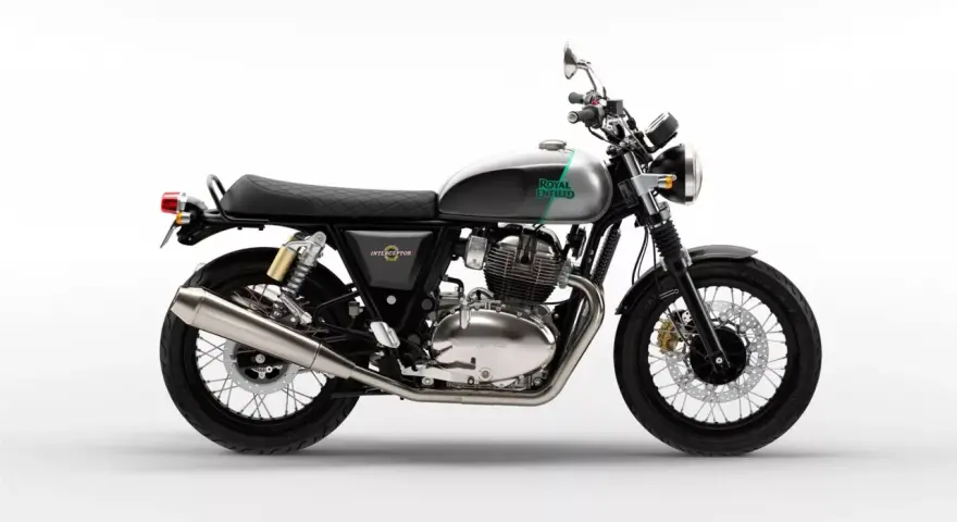 Stylowy Royal Enfield Interceptor 650 w kolorze szaro-zielonym, z chromowanym silnikiem i czarnym, pikowanym siedzeniem, gotowy na każdą podróż.