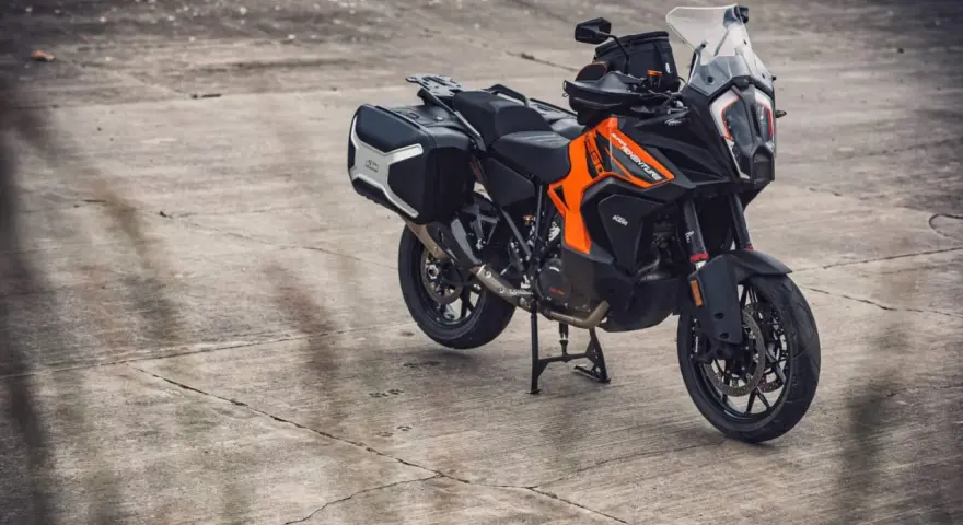 Pomarańczowo-czarny motocykl KTM 1290 Super Adventure z kuframi, gotowy na każdą wyprawę.