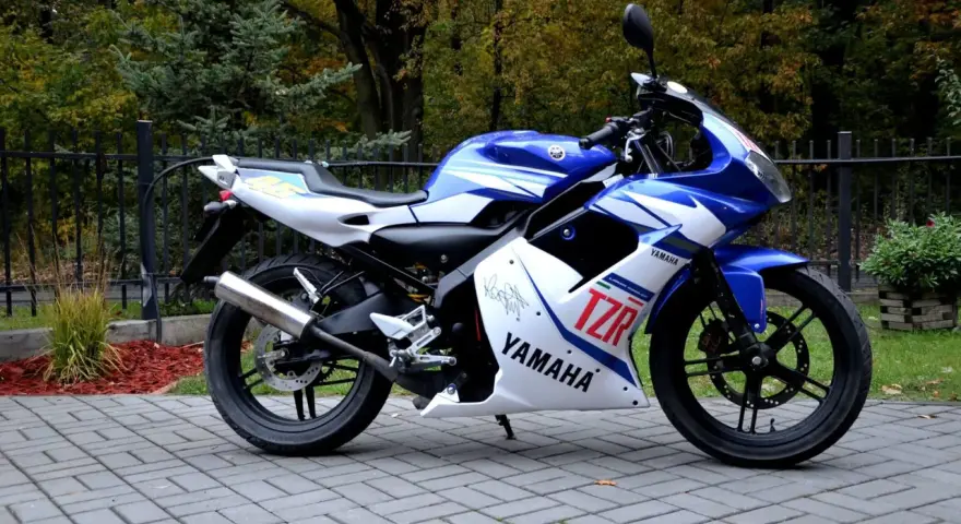 Sportowy motocykl Yamaha TZR 50 w niebiesko-białych barwach, gotowy do jazdy. Sprawdź jego atrakcyjną yamaha tzr 50 cena!