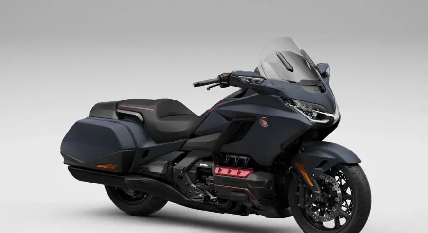 Ciemnoszary motocykl Honda Gold Wing z czarnym siedzeniem i kuframi, gotowy na dalekie podróże.