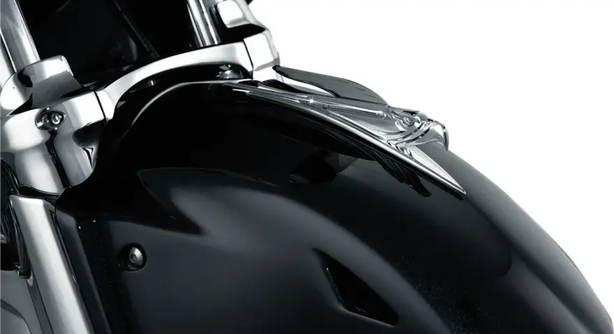 Błyszcząca, czarna owiewka motocykla z chromowanym orłem na przodzie.