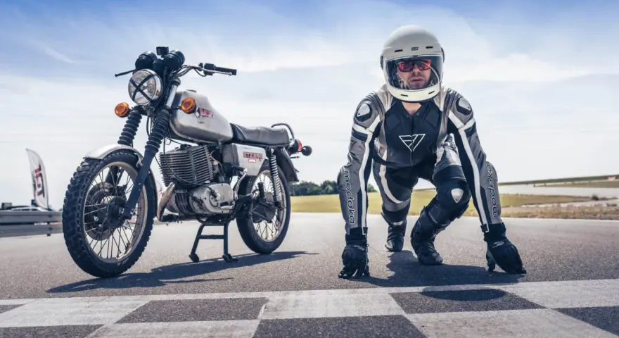 Motocykl MZ ETZ 250 i zawodnik w kombinezonie i kasku na starcie wyścigu. Gotowi do startu!
