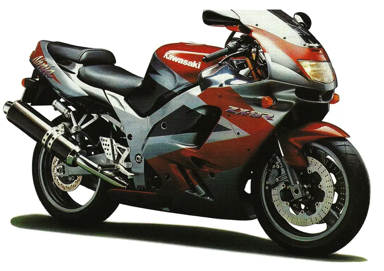 Sportowy motocykl Kawasaki ZX9R w czerwono-srebrnym malowaniu, gotowy do szaleństw na torze.