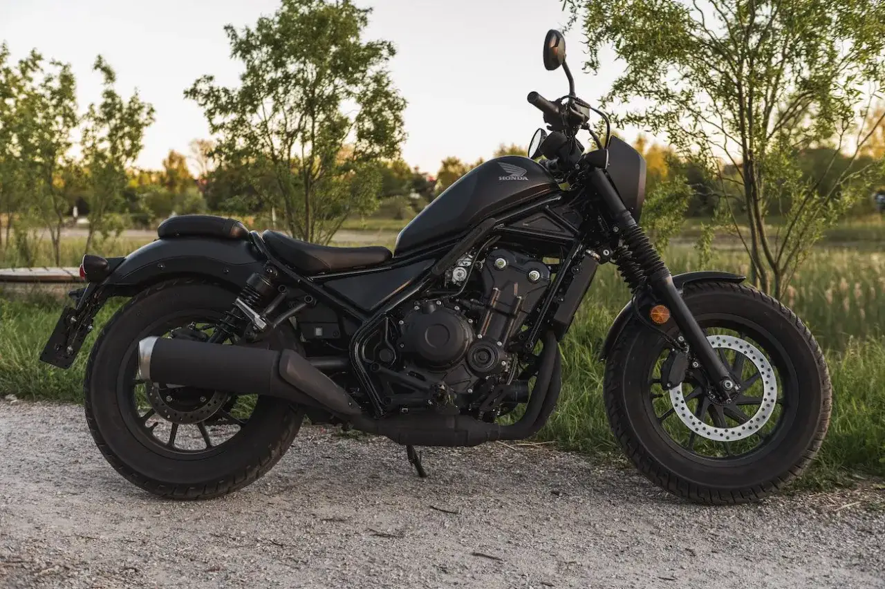 Czarny motocykl Honda Rebel 500, gotowy do jazdy, z potencjałem do osiągnięcia dużej prędkości maksymalnej.