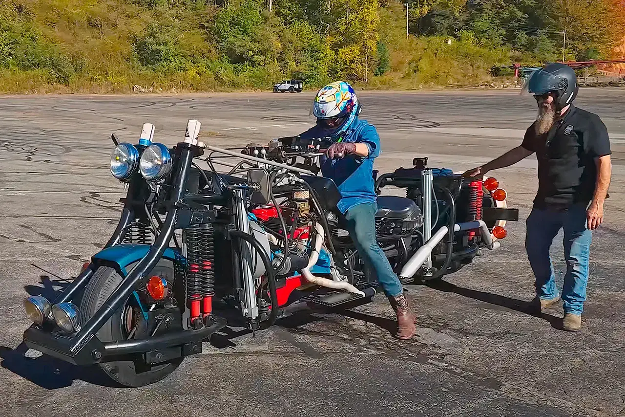 Oto największy motor na świecie, gotowy do jazdy. Dwóch mężczyzn w kaskach przygotowuje się do przejażdżki.