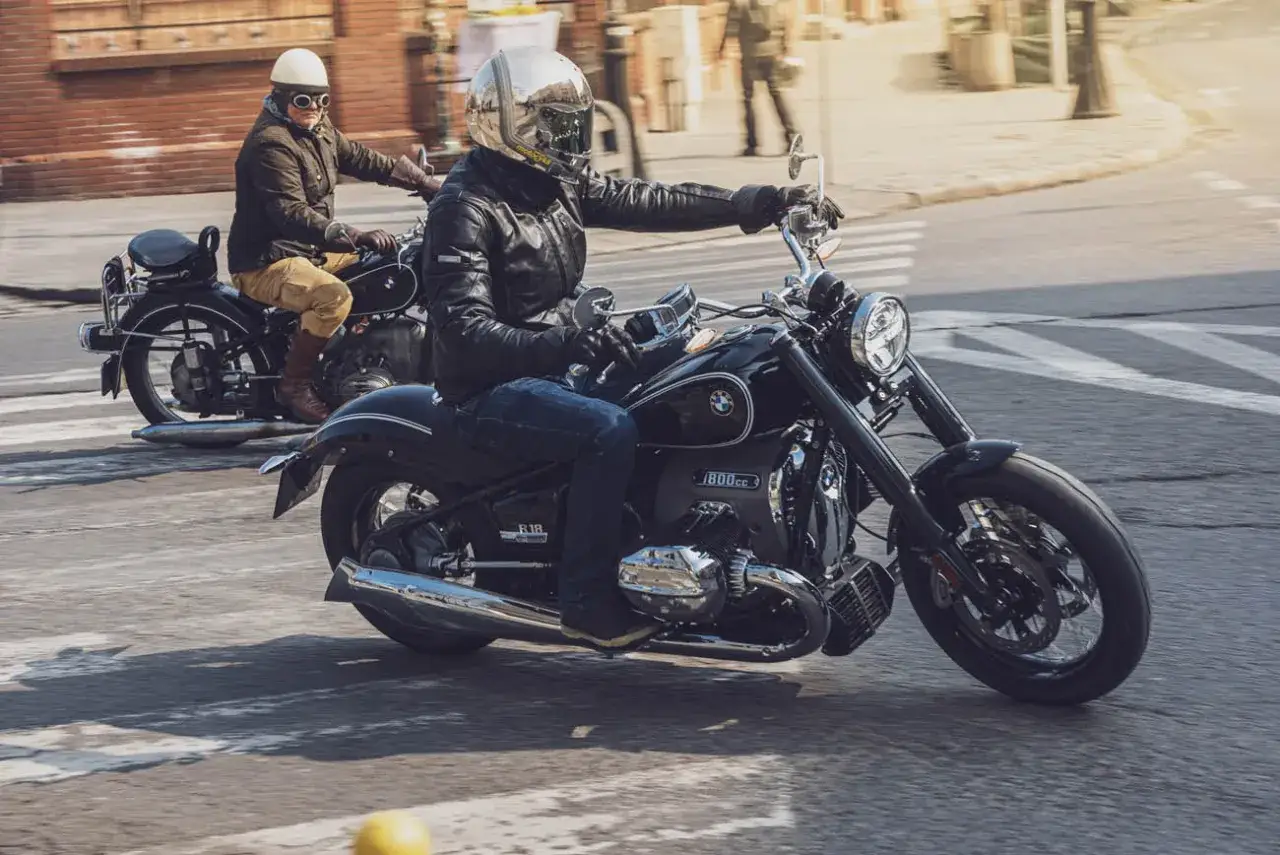 Dwóch motocyklistów na klasycznych maszynach. Z przodu lśniący motocykl BMW 1800, z tyłu starszy model. Cena tego BMW 1800 jest atrakcyjna.