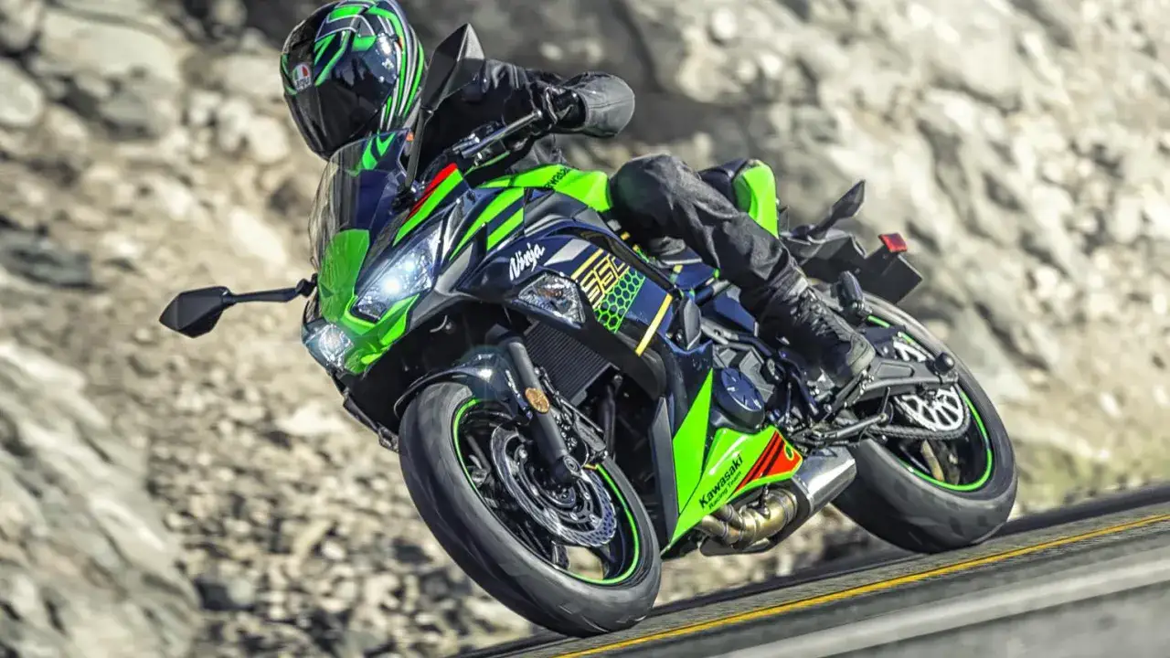Motocyklista w kasku ściga się na zielono-czarnym Kawasaki Ninja 650. Poznaj kawasaki ninja 650 dane techniczne.