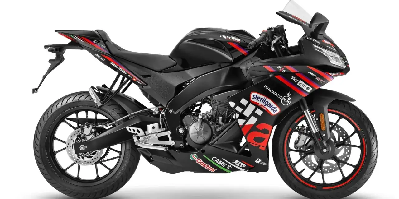 Czarny motocykl Aprilia RS4 z kolorowymi naklejkami sponsorów, gotowy do wyścigu.