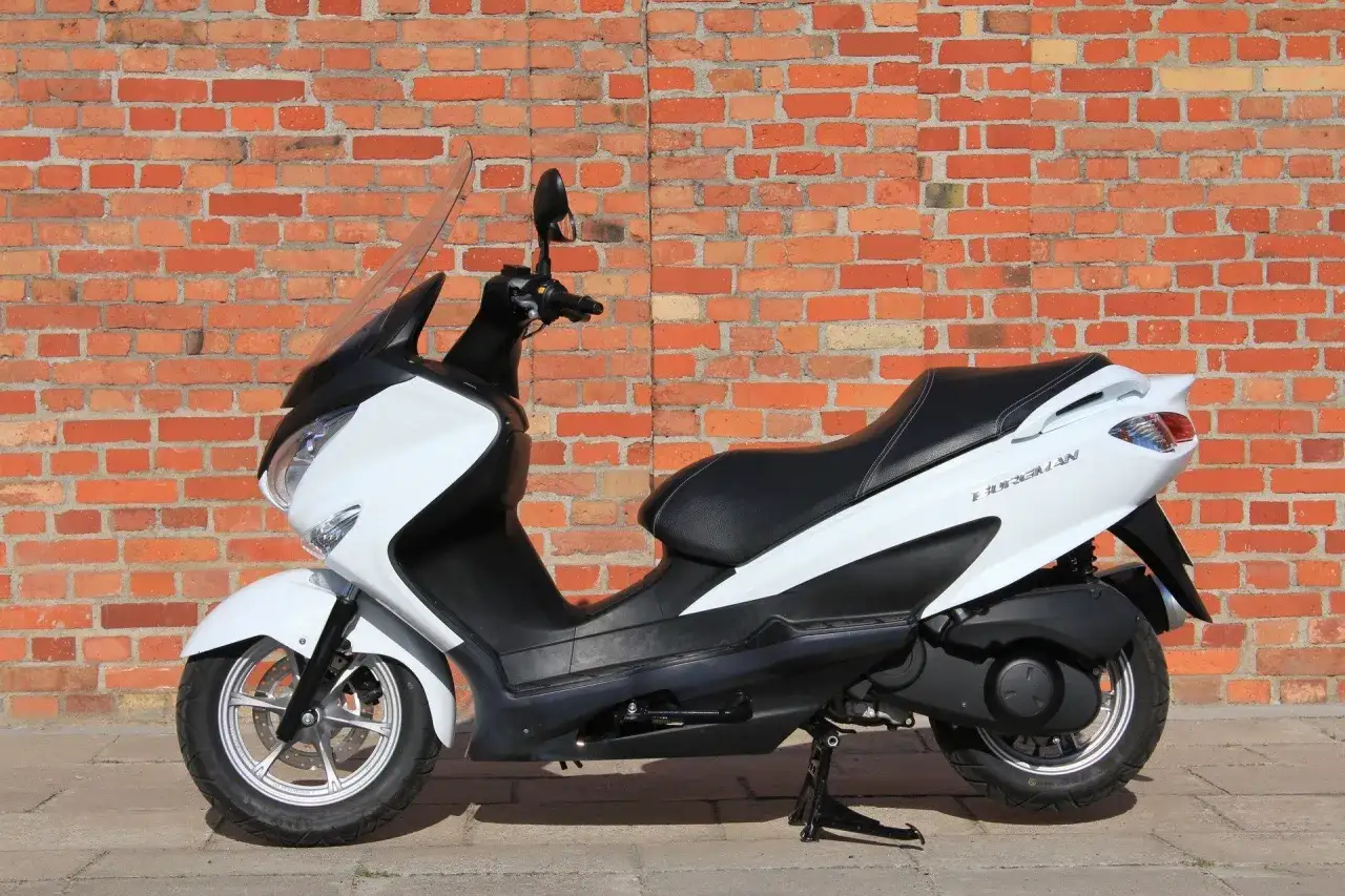 Biały skuter Suzuki Burgman 125, idealny do miasta, z niskim spalaniem.