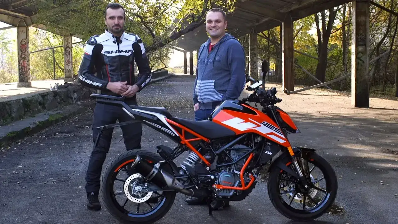 Dwóch mężczyzn obok pomarańczowo-czarnego motocykla KTM Duke 125. Poznajcie jego dane techniczne!