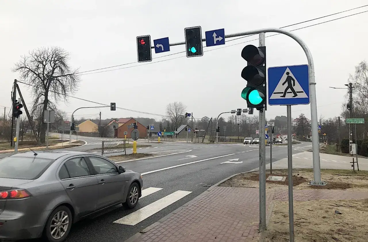 Zielone światła kolizyjne na skrzyżowaniu, samochód zbliża się do przejścia dla pieszych.