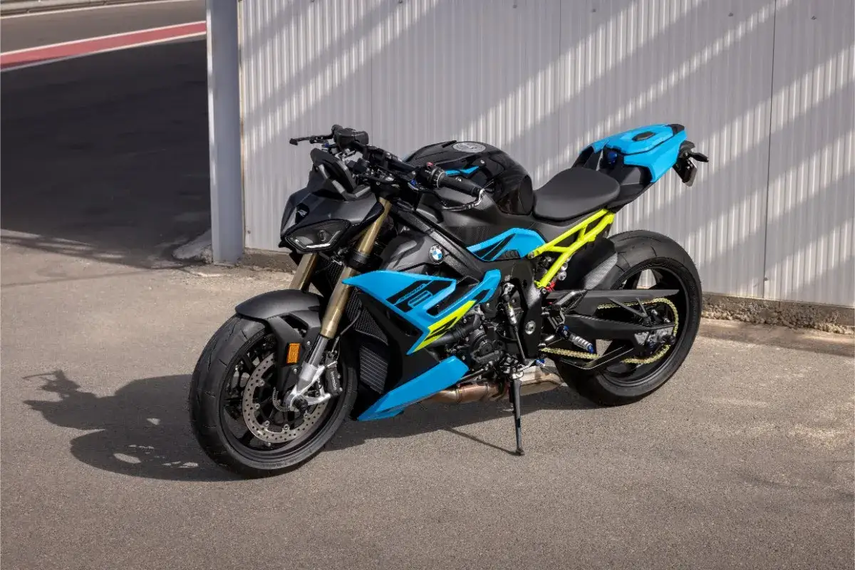 Potężny motocykl BMW S1000R w czarno-niebieskich barwach z żółtym stelażem, gotowy do jazdy po torze.