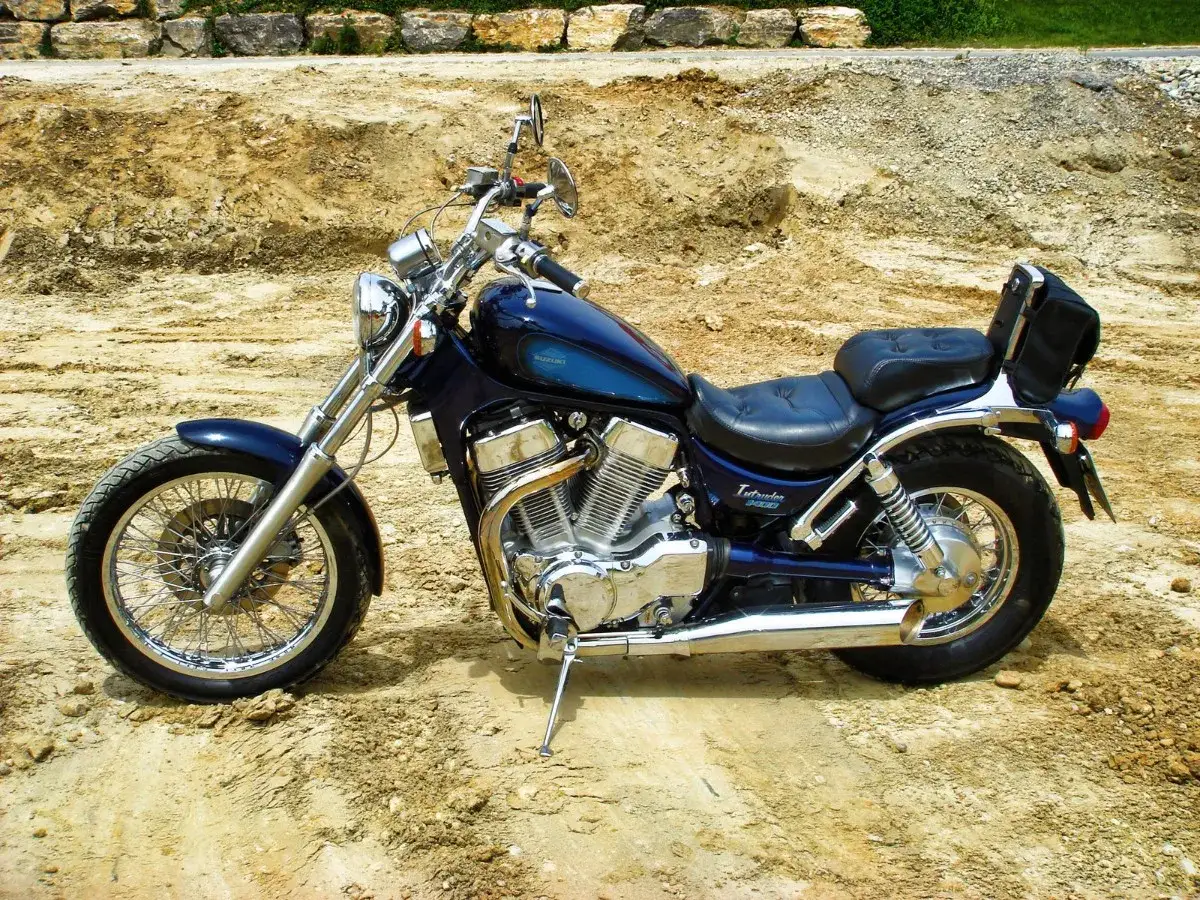 Ciemnoniebieski motocykl Suzuki Intruder 1400 na piaszczystym podłożu.