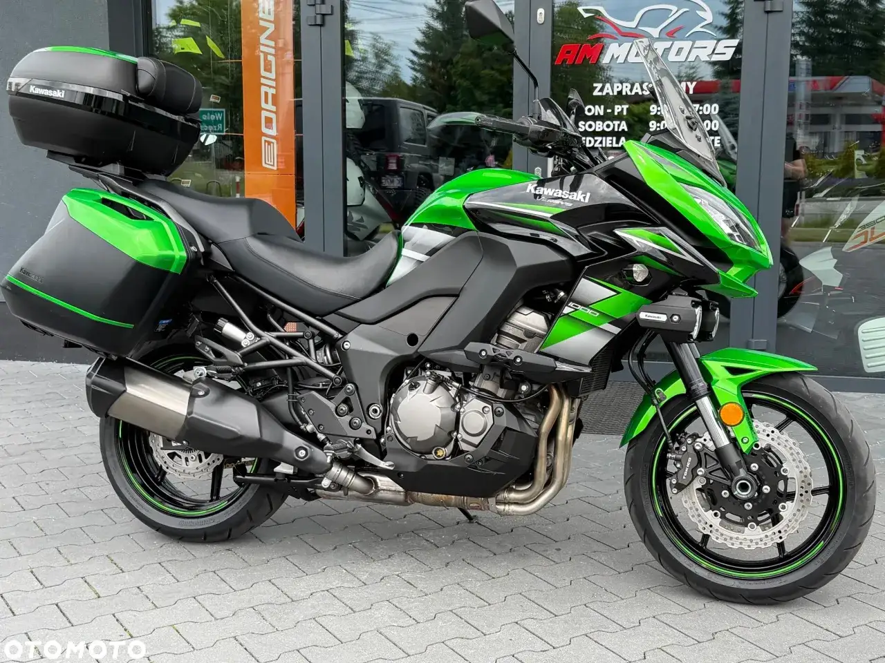 Zielony Kawasaki Versys 1000 z kuframi. Choć jego wady są dyskusyjne, to jego wygląd jest niepodważalny.