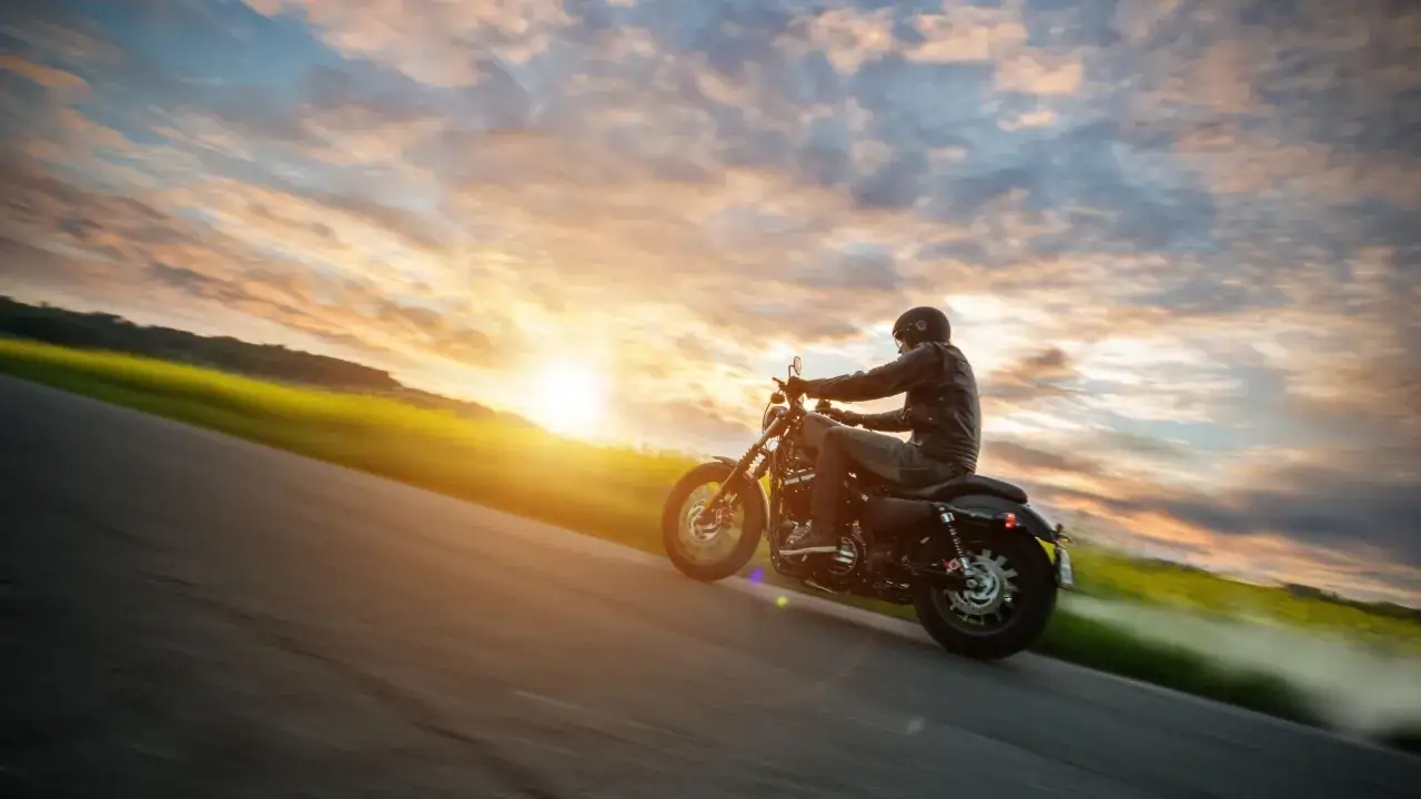 Motocyklista przemierza malownicze trasy motocyklowe Dolny Śląsk podczas zachodu słońca.