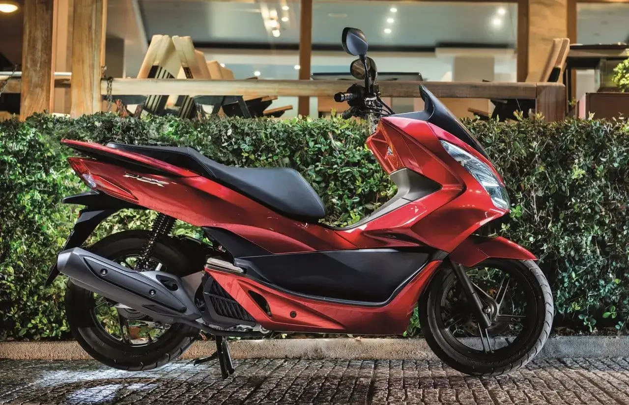 Lśniący czerwony skuter 125 cc, idealny na 15 km dojazdy do pracy. Elegancki design i komfortowa jazda.