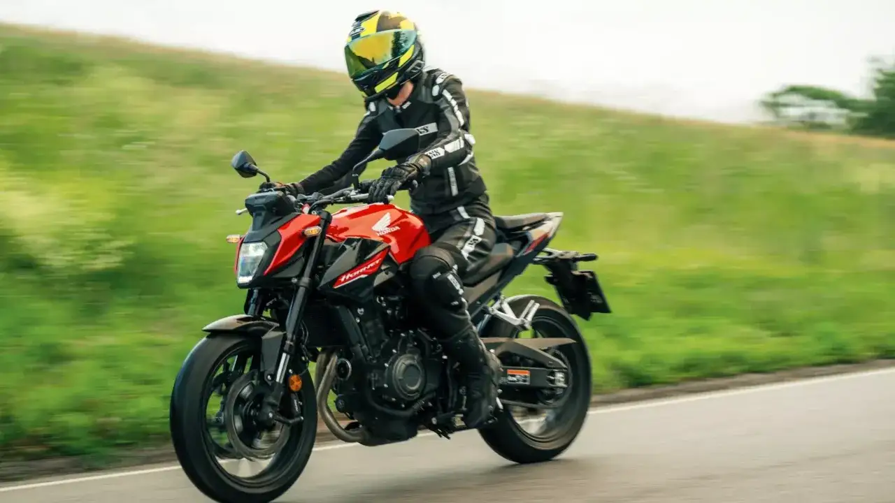 Motocyklista w kombinezonie jedzie na czerwonym motocyklu Honda CB 500. Poznaj honda cb 500 dane techniczne i poczuj wolność!