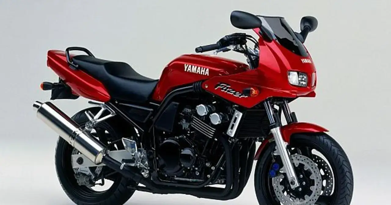 Czerwony motocykl Yamaha Fazer z błyszczącym wydechem i sportową owiewką.