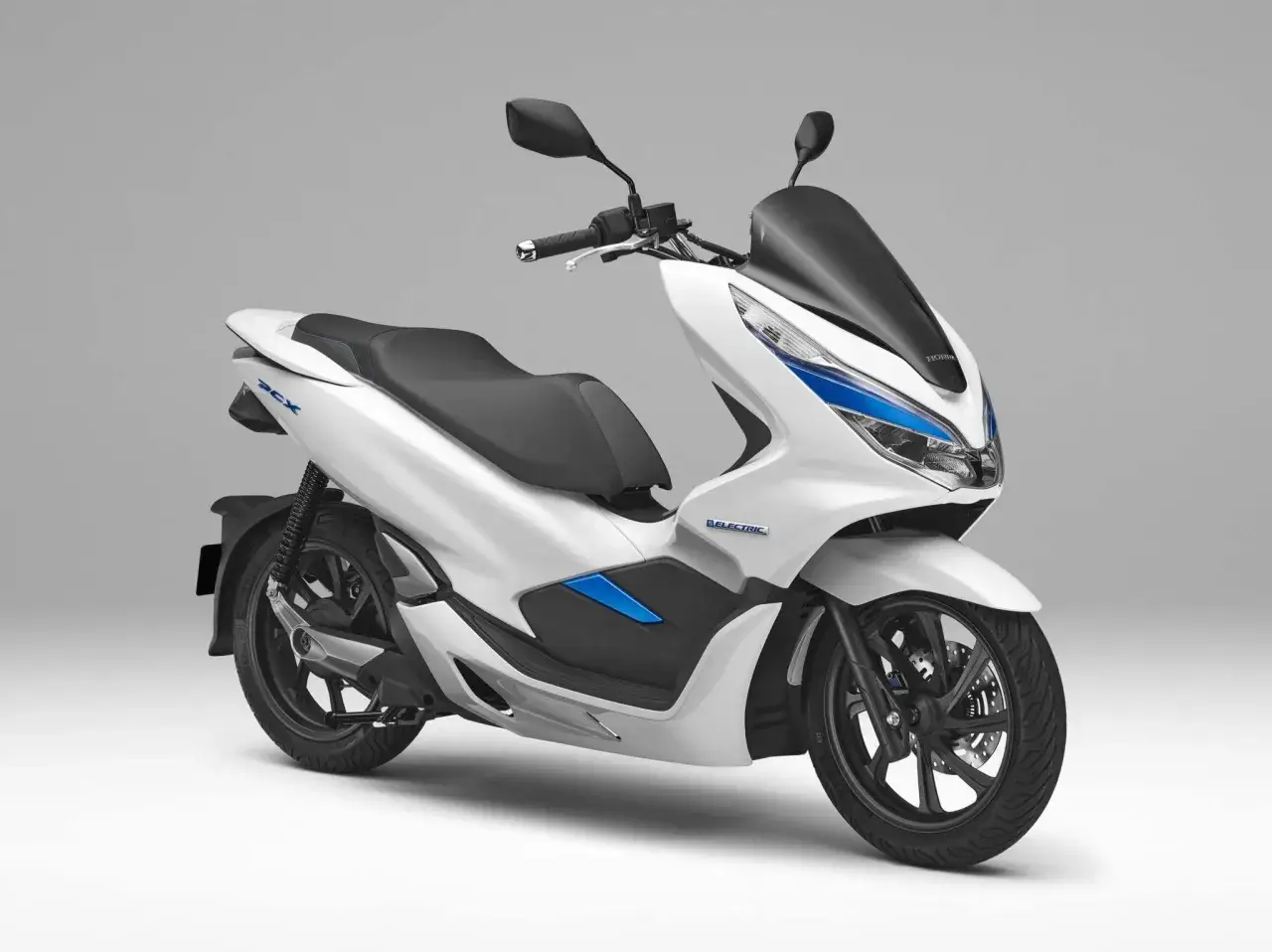 Biały pojazd silnikowy jednośladowy Honda PCX Electric z czarnym siedzeniem i przyciemnianą szybą.