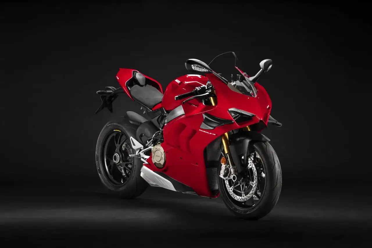 Czerwony motocykl Ducati Panigale V4 z czarnym siedzeniem i detalami, prezentowany na ciemnym tle.