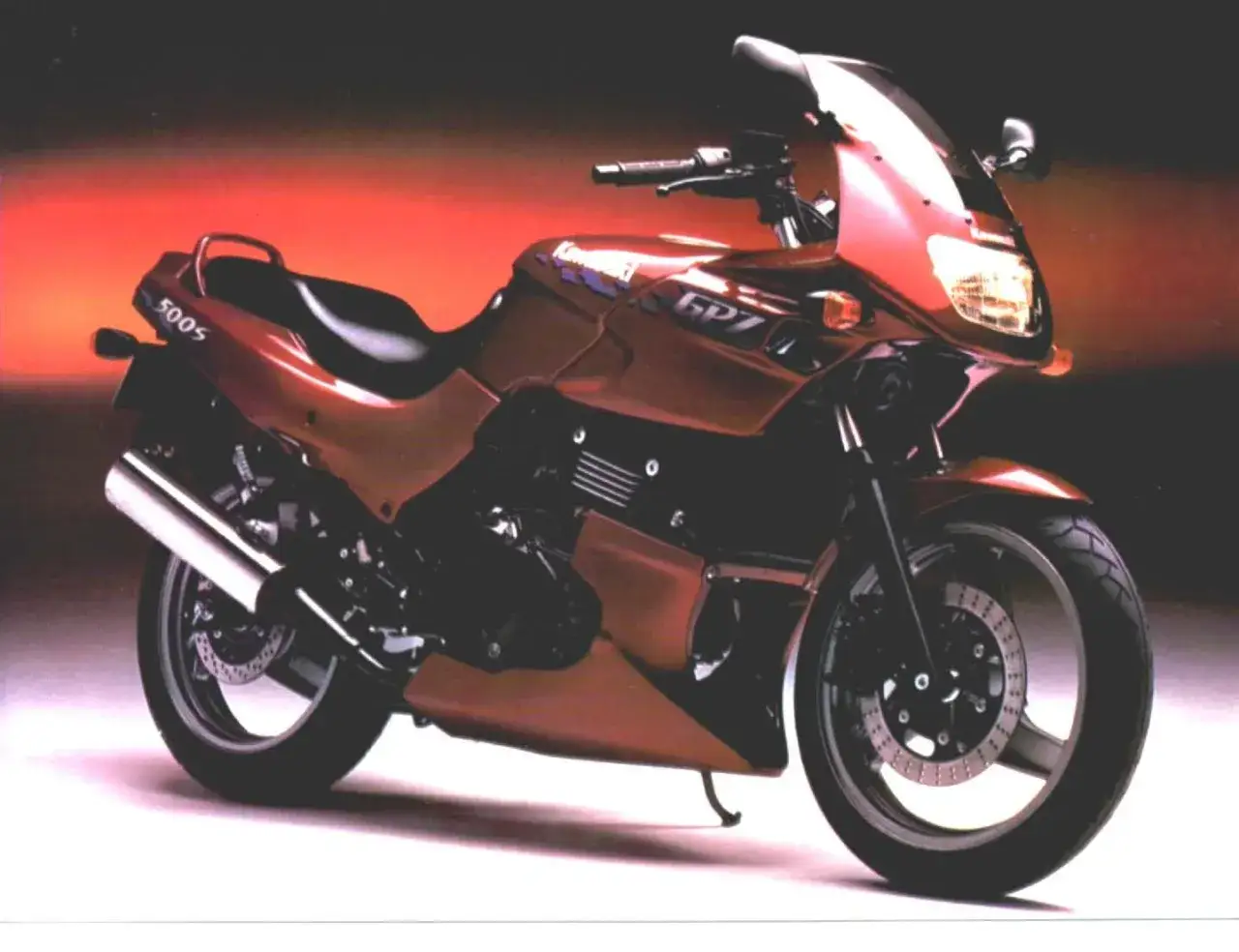 Czerwony motocykl Kawasaki GPZ 500s z lat 90. z błyszczącym wydechem i sportową sylwetką.