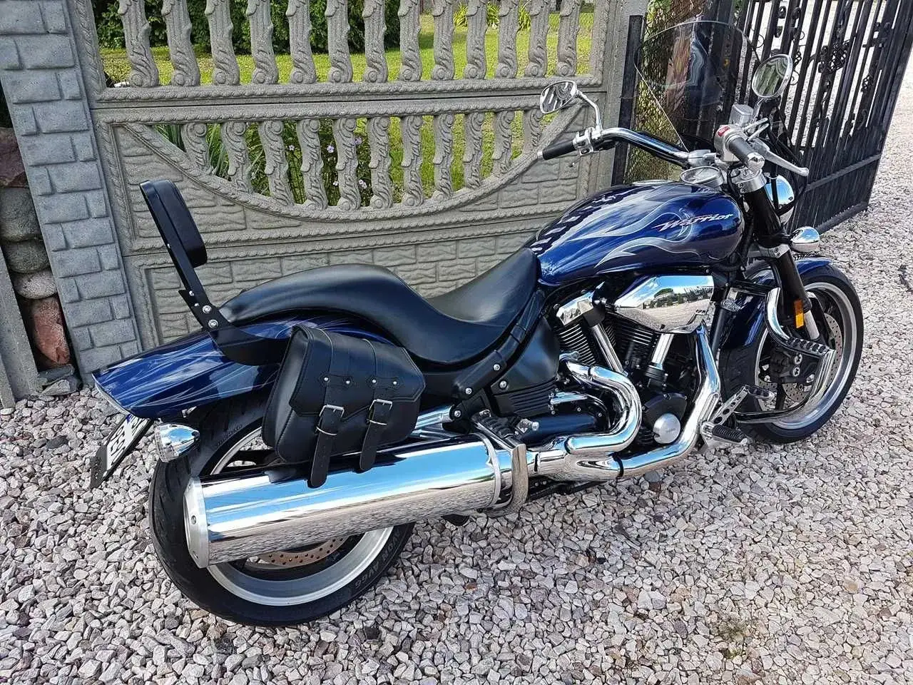 Błyszczący, granatowy Yamaha Warrior 1700 z chromowanymi elementami i skórzaną sakwą, gotowy na podróż.