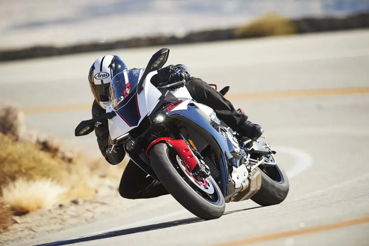 Motocyklista pochyla się na zakręcie na sportowym motocyklu Yamaha R1 2016.