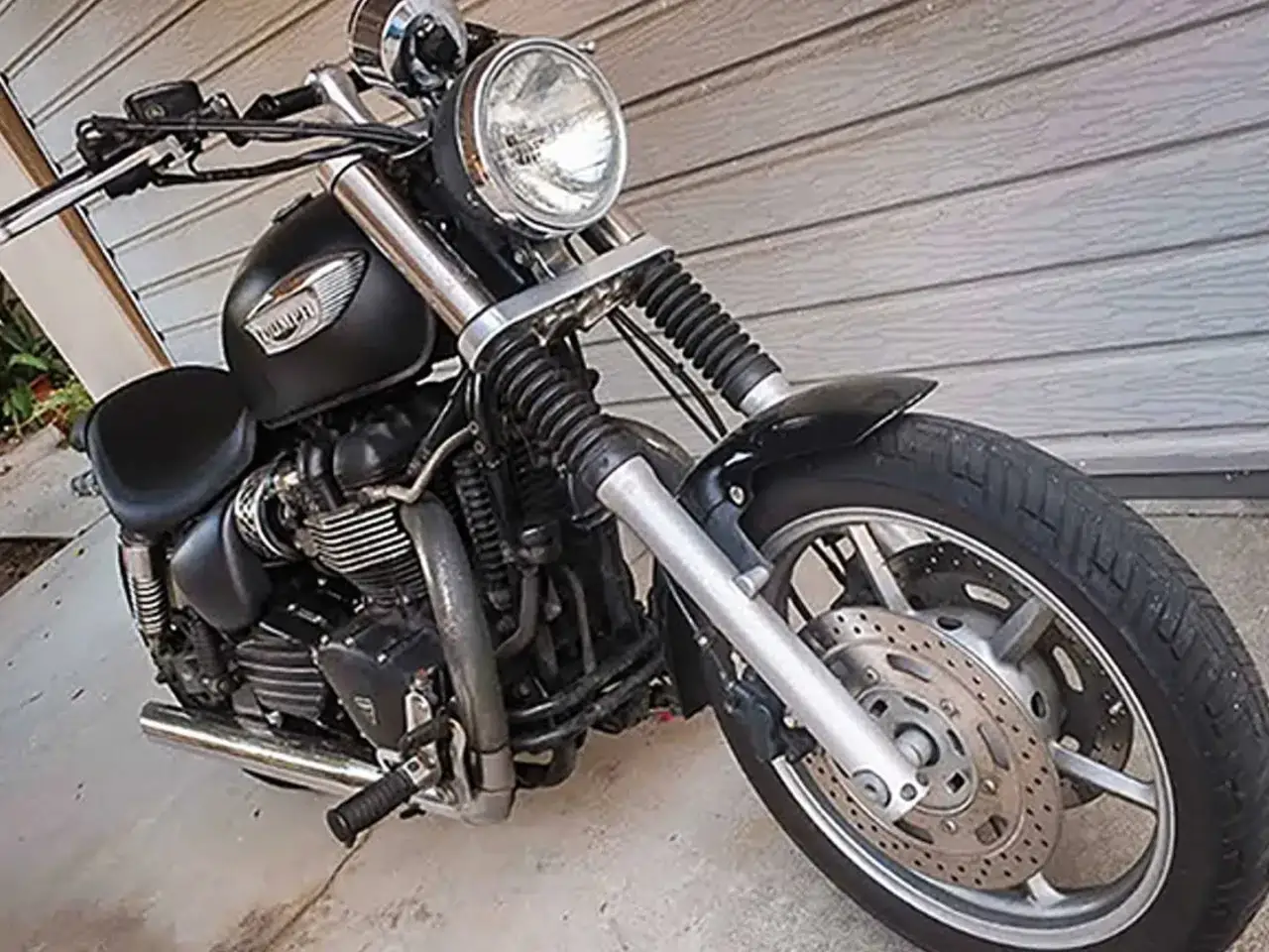 Czarny motocykl Triumph Speedmaster z chromowanymi elementami, gotowy na przygodę.