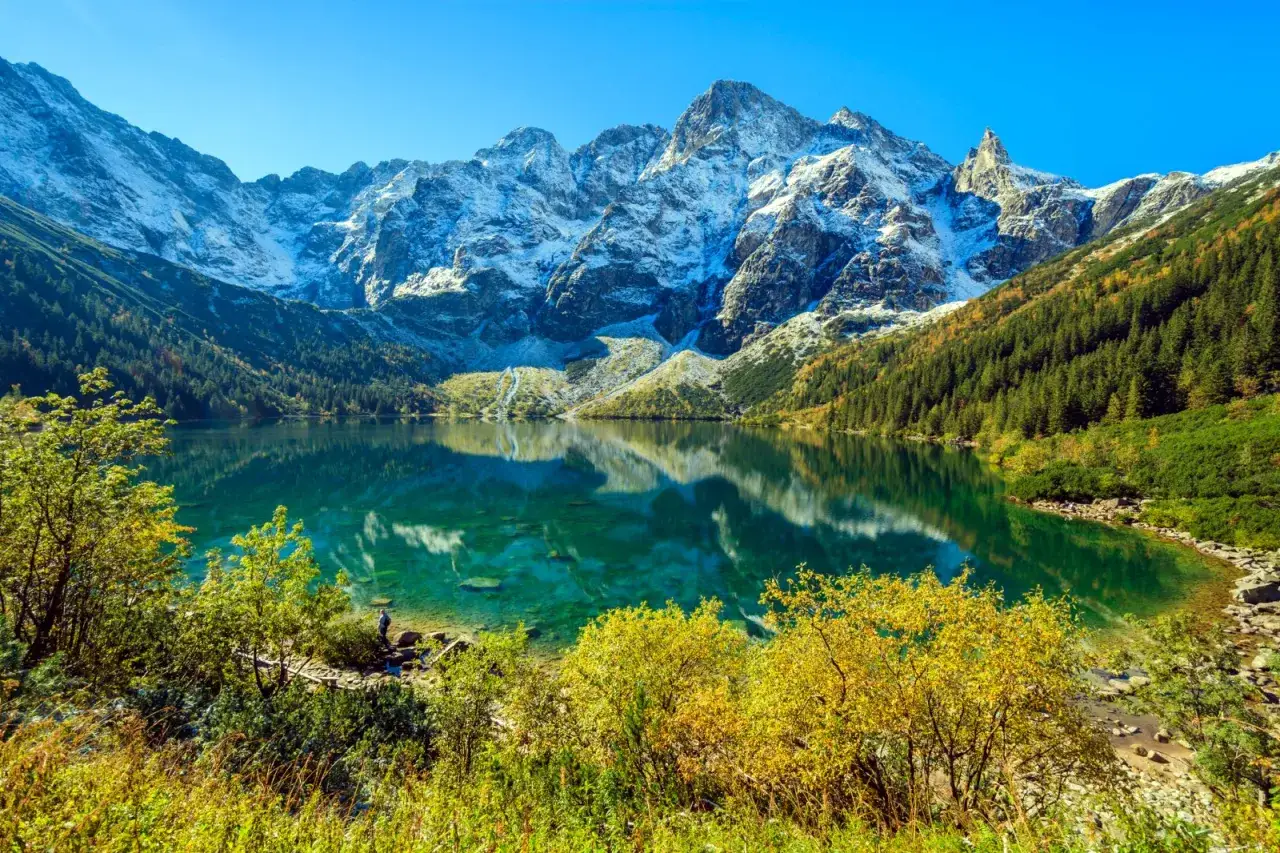 Piękna droga na Morskie Oko. Turkusowa tafla jeziora odbija ośnieżone szczyty Tatr i jesienne lasy.