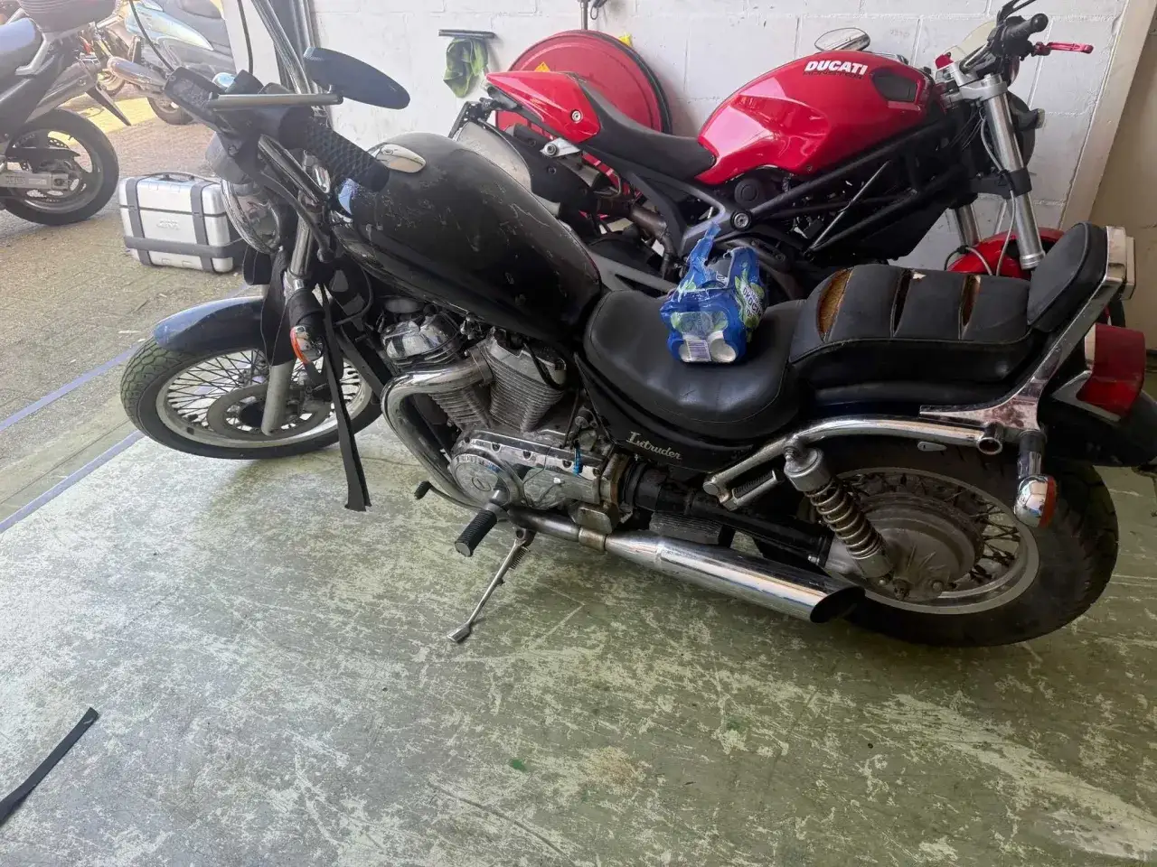 Czarny Suzuki Intruder 800, obok czerwonego Ducati. Wady i zalety tego klasyka choppera widać na pierwszy rzut oka.