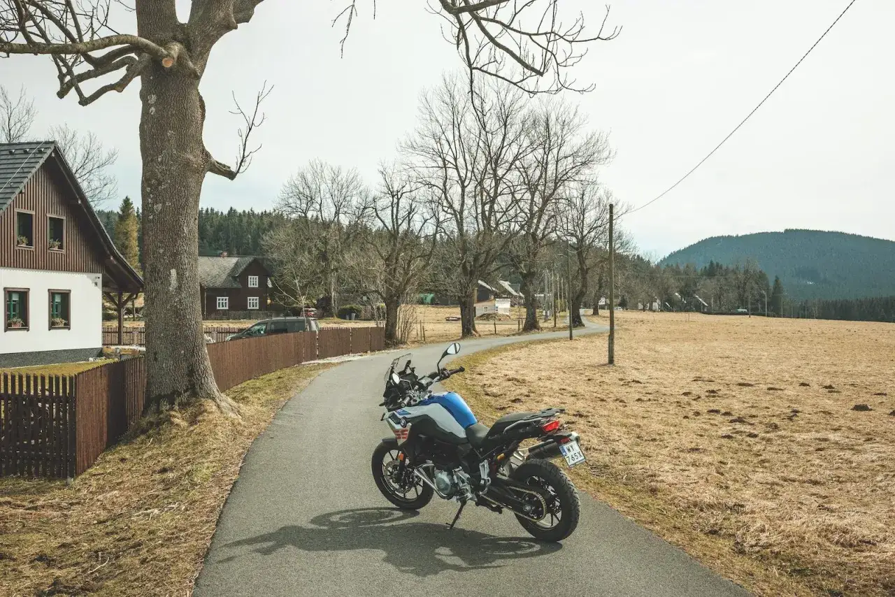 Motocykl czeka na przygodę na malowniczej drodze. Idealne miejsce na odkrywanie tras motocyklowych w Czechach.