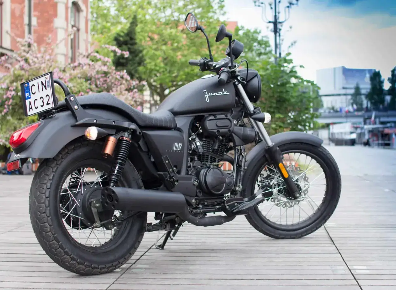 Czarny motorower Junak M12 Vintage na drewnianej desce. Zastanawiasz się, ile kosztuje motorower?
