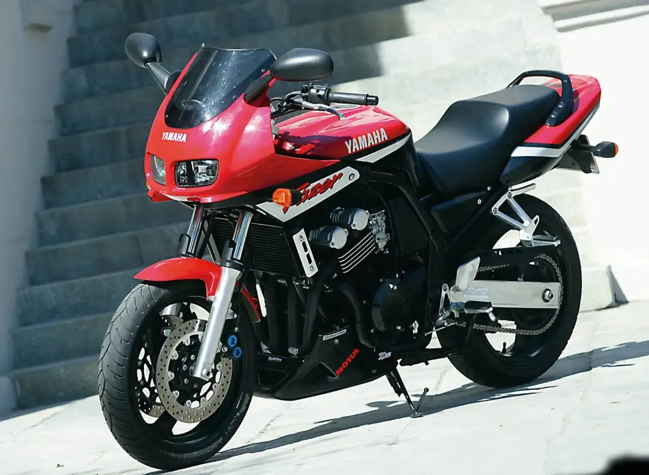 Czerwony motocykl Yamaha Fazer 600, z widocznymi detalami silnika i napędu. Idealny do miasta i na trasy, sprawdź yamaha fazer 600 dane techniczne.