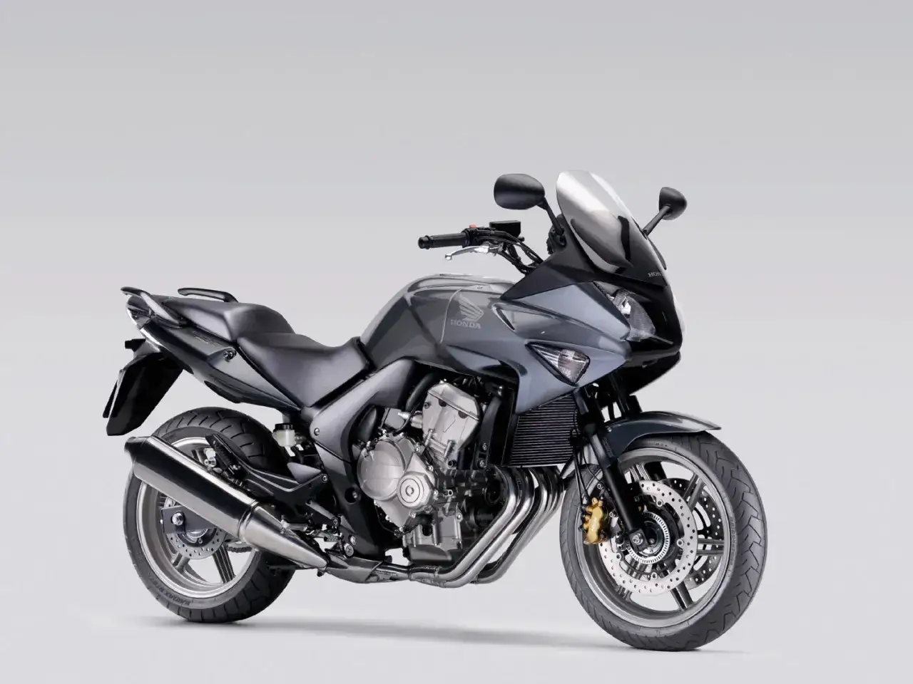 Szary motocykl Honda CBF 600, zgrabny i zwinny, jego waga jest idealnie wyważona.