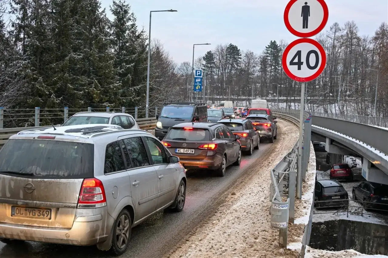 Korek na zakopiance. Śnieg i błoto na drodze, znaki ograniczenia prędkości i zakazu ruchu pieszego.