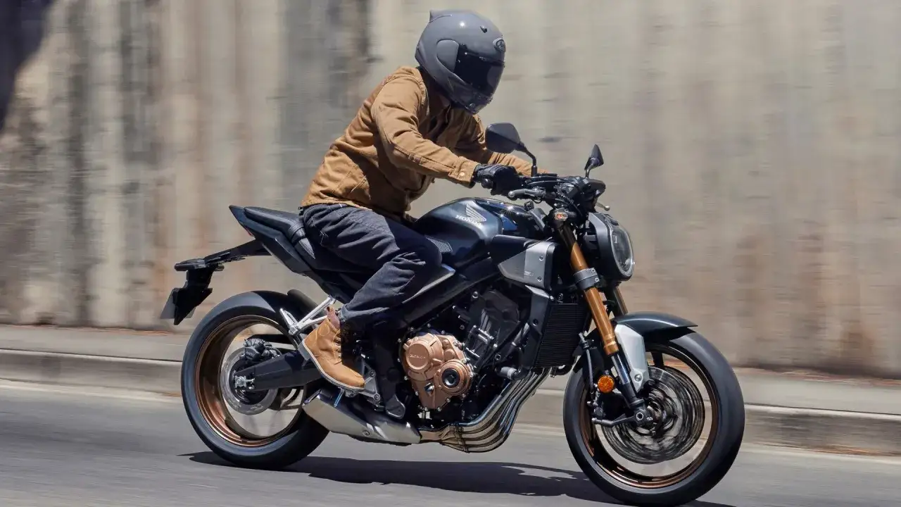 Motocyklista w kasku i brązowej kurtce pędzi na swoim hyper naked motocyklu Honda, czuć wolność i moc.