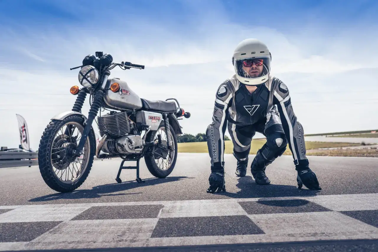 Motocykl MZ ETZ 250 i zawodnik w kombinezonie i kasku na starcie wyścigu. Gotowi do startu!