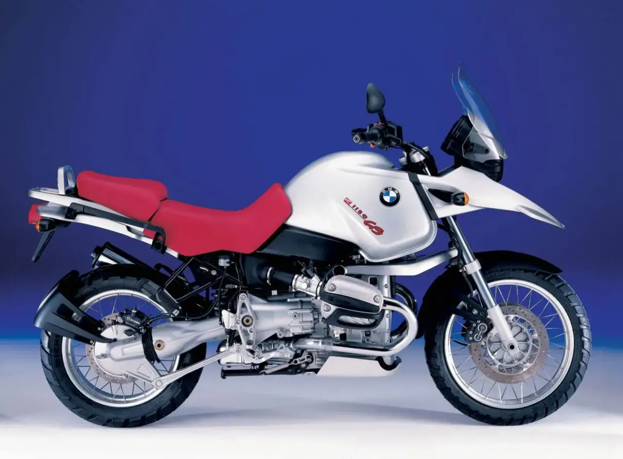 Srebrny motocykl BMW GS 1150 z czerwoną kanapą, gotowy na przygodę.